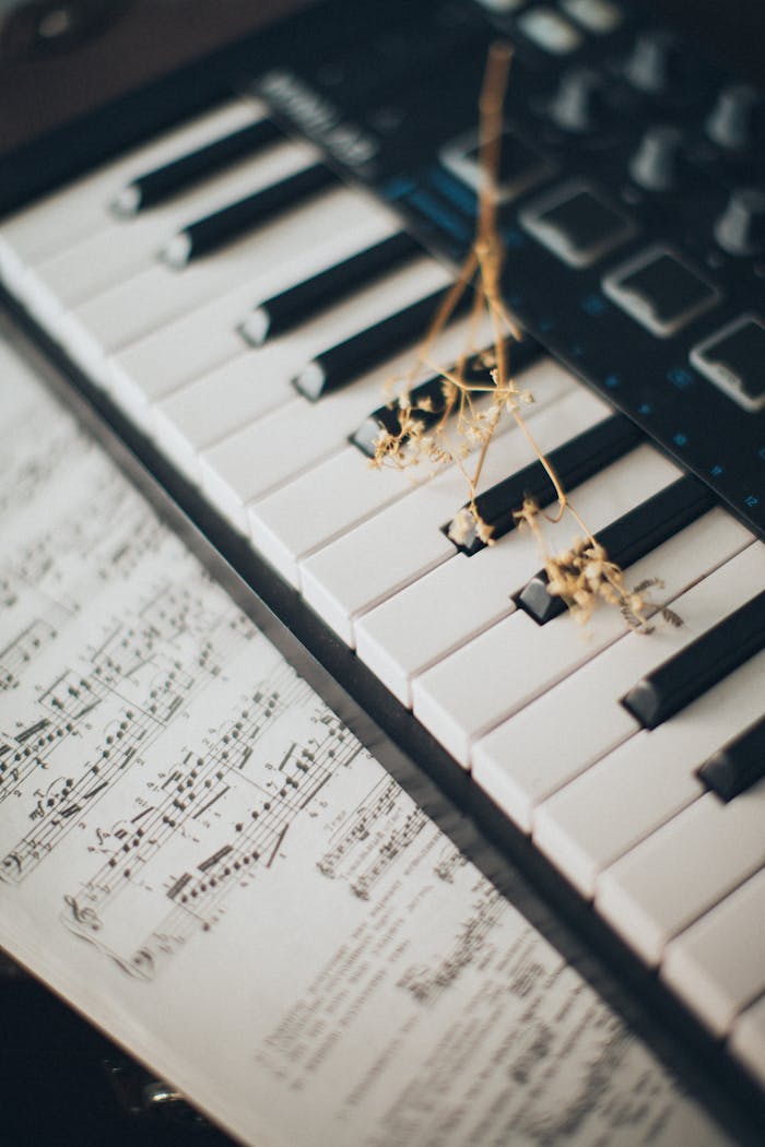 portfolio-06 Close-up of piano keys with a flower and sheet music creates an artistic and musical ambiance.